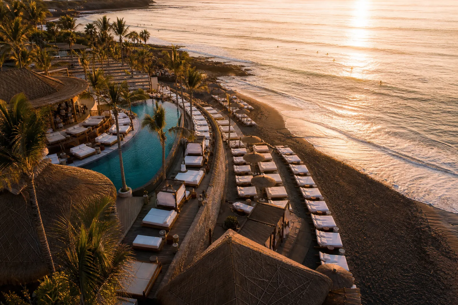 Bali beach club at sunset with daybeds facing the ocean
