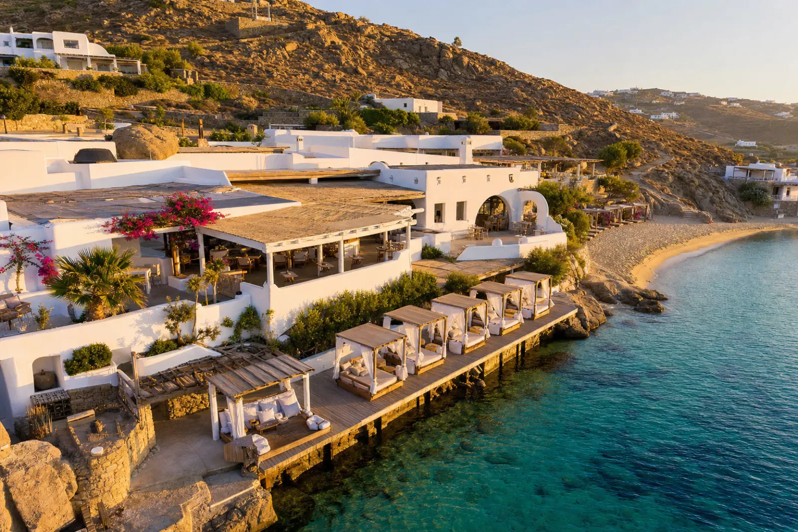 Mykonos beach club with whitewashed Cycladic architecture and premium daybeds by the Aegean