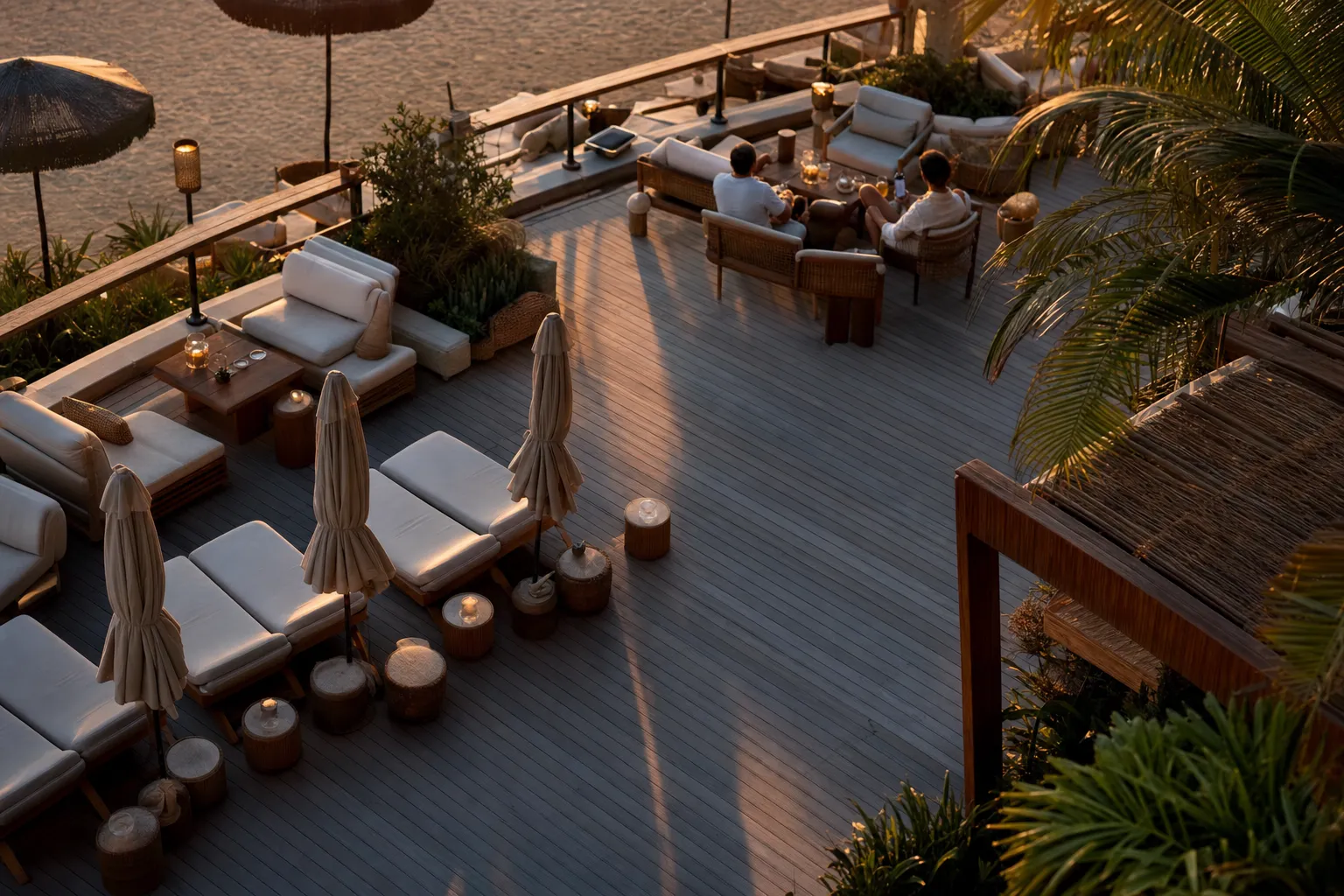 Beach club seating plan viewed from above at golden hour with part of the furniture occupied and part still empty