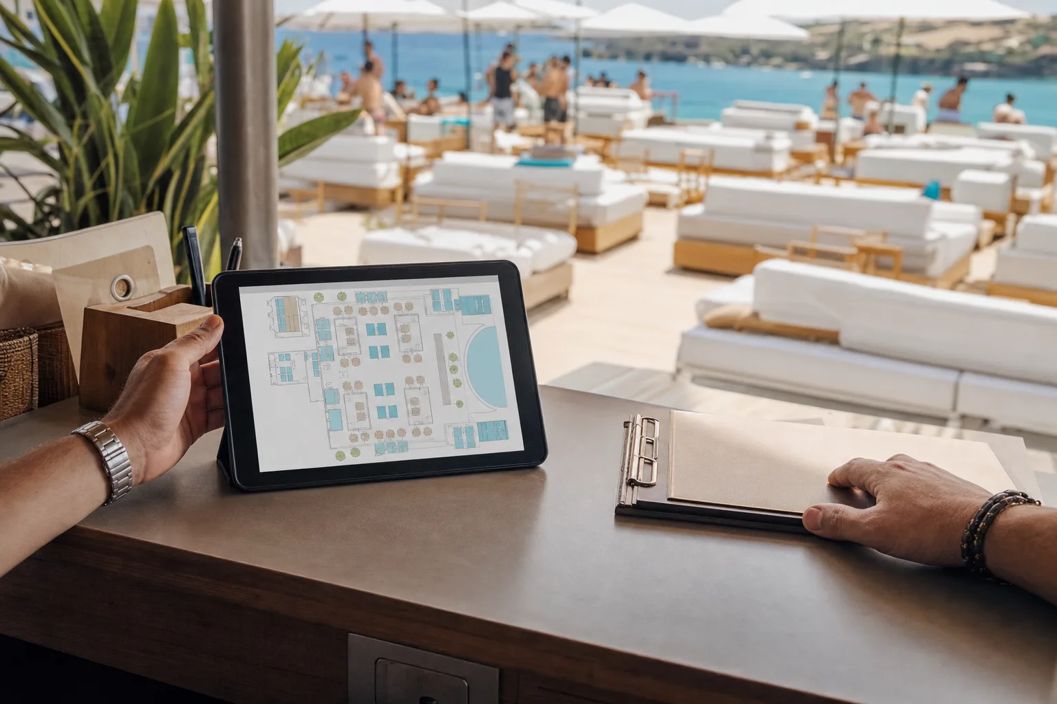A venue manager checking an interactive floor plan on a tablet while a paper clipboard sits pushed aside